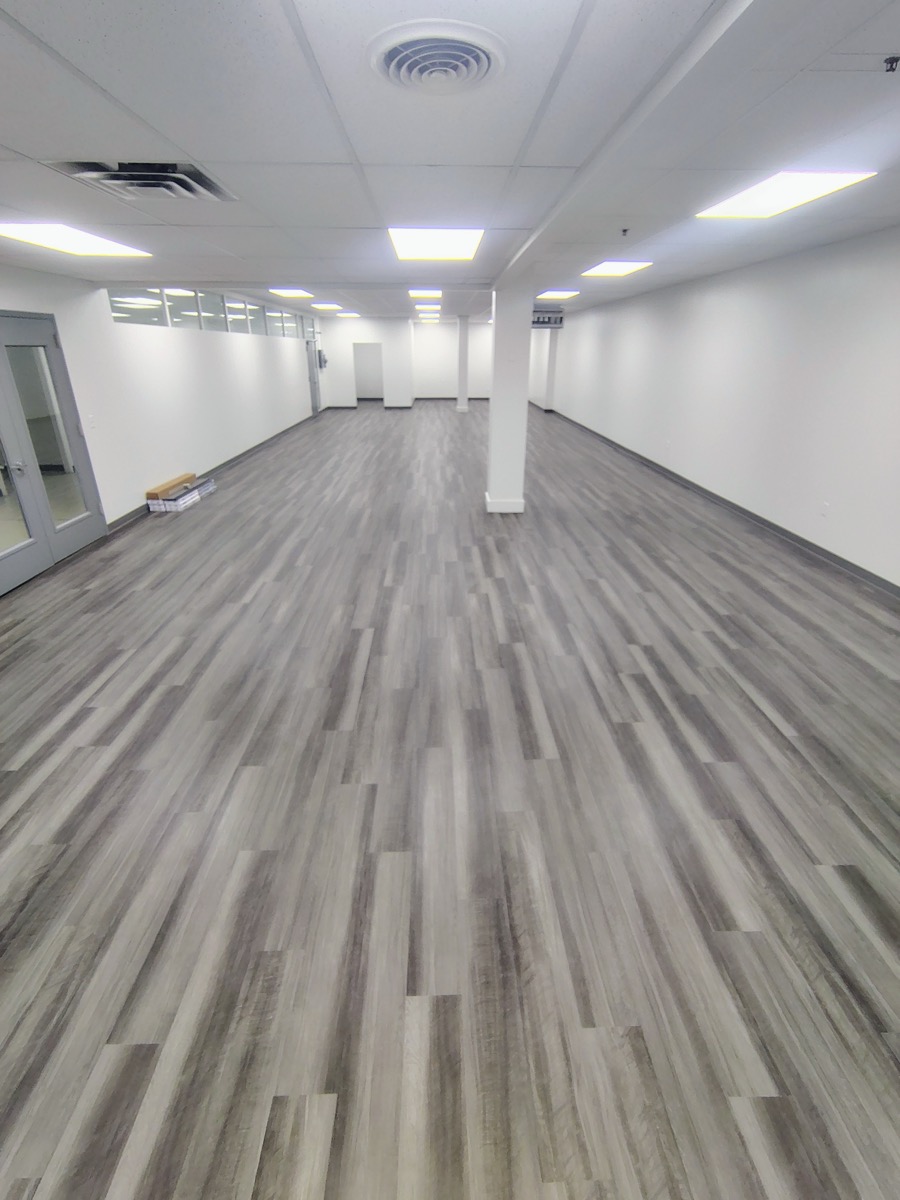 Grey vinyl plank flooring completed in a wide commercial space