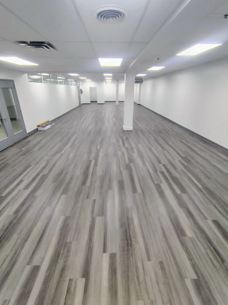 Grey vinyl plank flooring completed in a wide commercial space