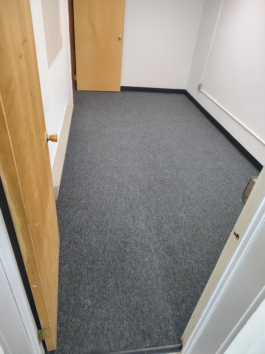 Dark grey carpet flooring installed in a small office space